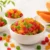 Colorful tutti frutti candied papaya cubes in bowls with fresh papaya